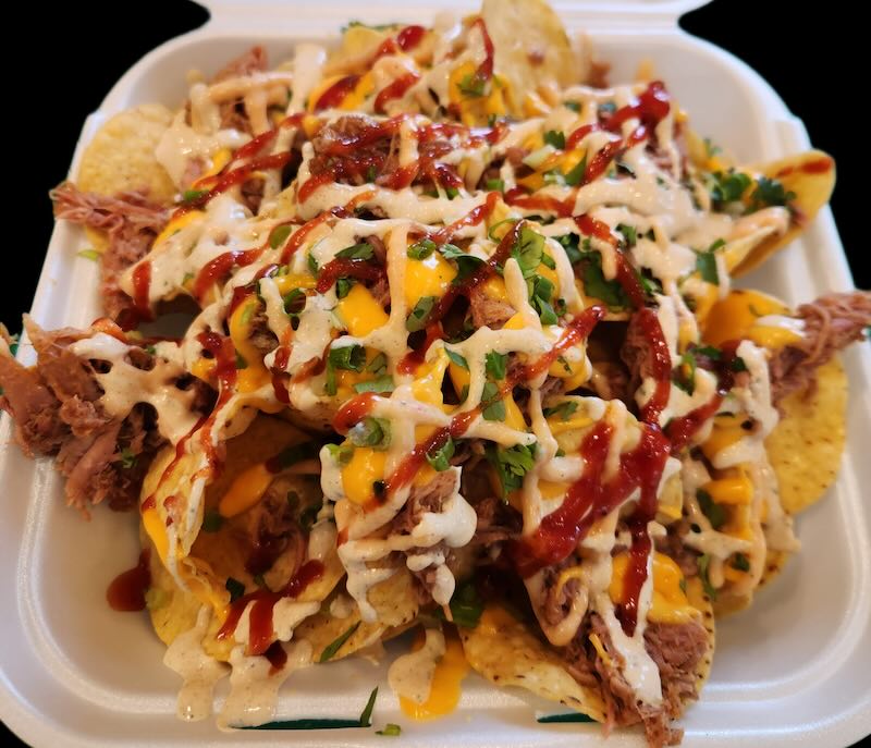 A to-go tray full of loaded nachos